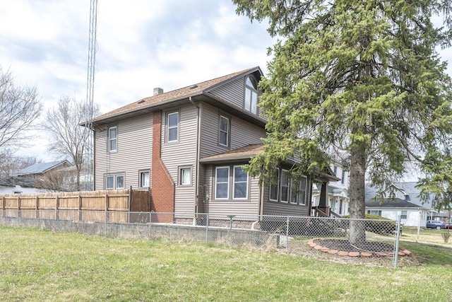 rear view of house with a chimney, fence private yard, and a yard