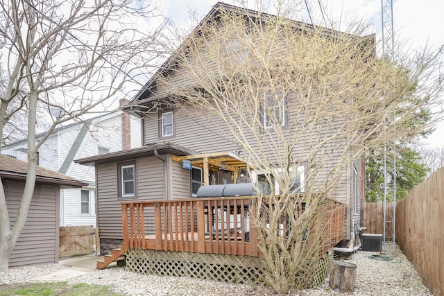 rear view of house featuring a fenced backyard, central air condition unit, and a deck