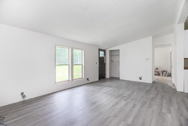 13253 State Route 720, Lakeview, OH 43331 - unfurnished living room with light wood-style flooring and vaulted ceiling