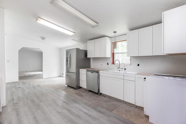 13253 State Route 720, Lakeview, OH 43331 - kitchen with appliances with stainless steel finishes, white cabinetry, arched walkways, hanging light fixtures, and light wood-style floors