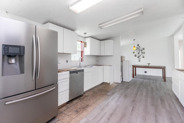 13253 State Route 720, Lakeview, OH 43331 - kitchen featuring appliances with stainless steel finishes, white cabinetry, decorative light fixtures, and light wood-type flooring