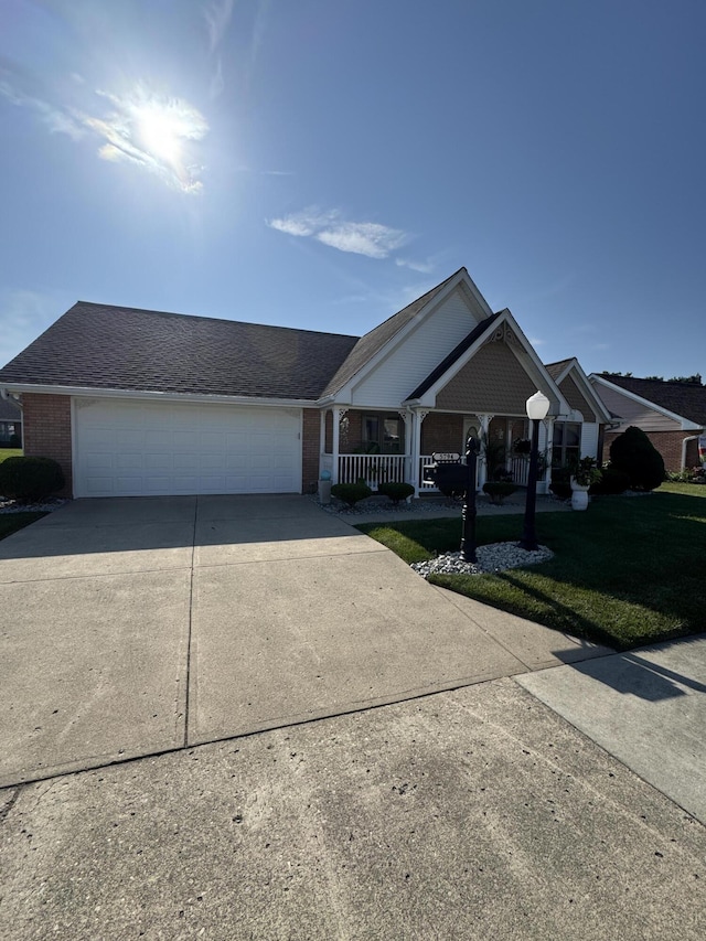 5794 Winfield Dr, Springfield, OH 45503 - view of front of property with driveway, a porch, a garage, a front lawn, and brick siding