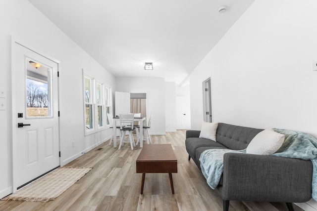 living area with light wood-style flooring and baseboards