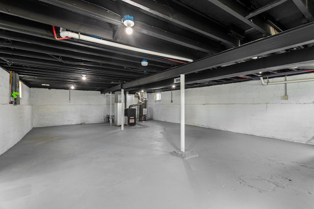 unfinished basement featuring heating unit and water heater