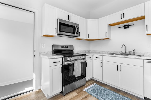 kitchen featuring a sink, white cabinetry, appliances with stainless steel finishes, and light countertops