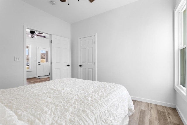 bedroom with ceiling fan, baseboards, and light wood-style flooring