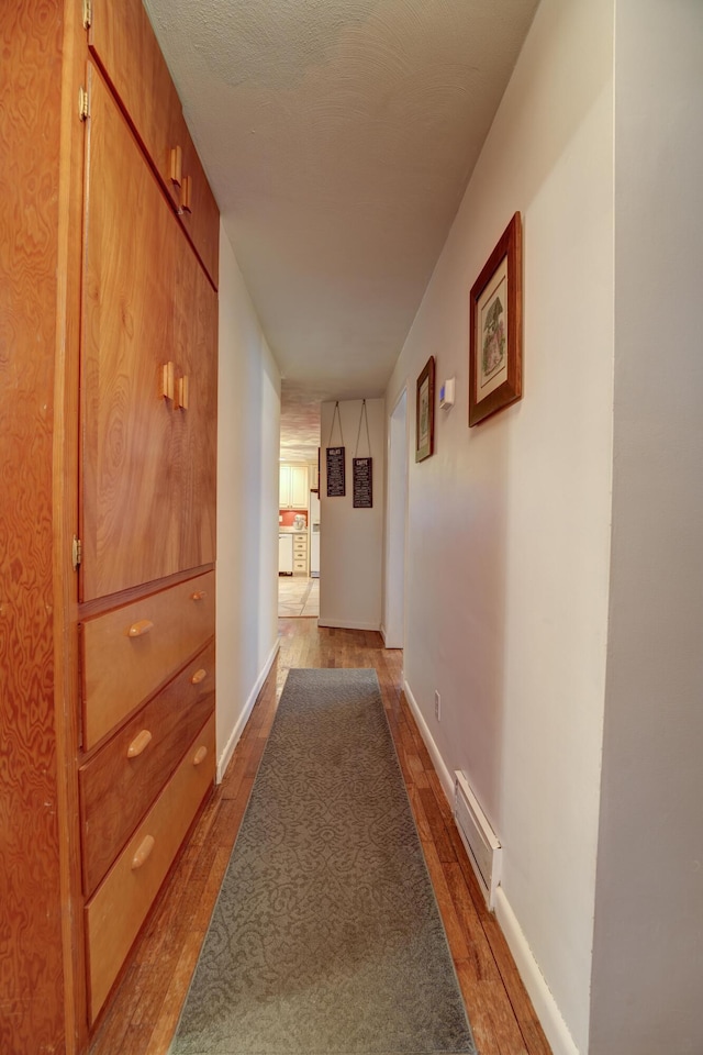 corridor with visible vents, baseboards, and dark wood-style flooring