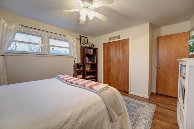 bedroom featuring a closet, baseboards, ceiling fan, and wood finished floors