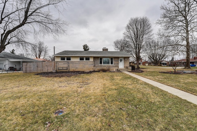 view of front of home featuring stone siding, a chimney, a front yard, and fence