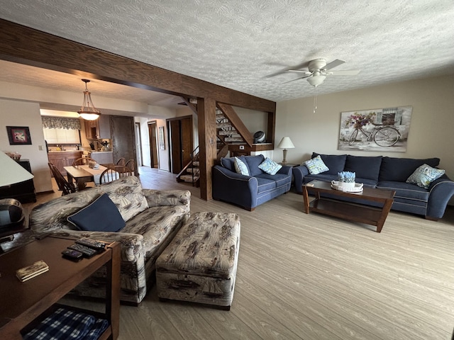 10209 County Road 286 Unit C-16, Huntsville, OH 43324 - living area featuring a textured ceiling, ceiling fan, wood finished floors, and stairs