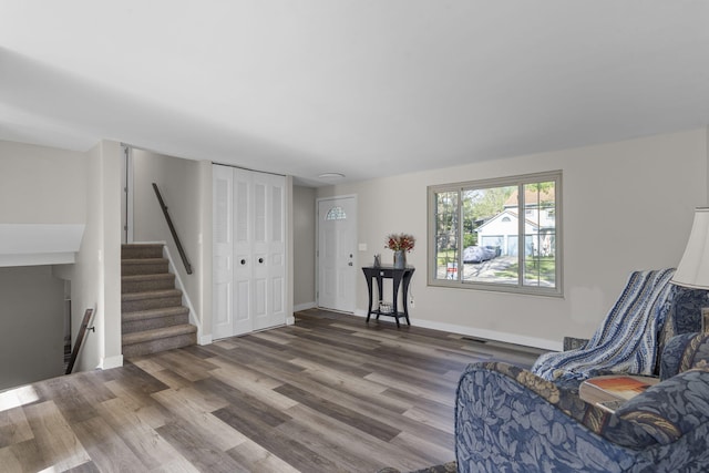 sitting room with visible vents, stairs, baseboards, and wood finished floors