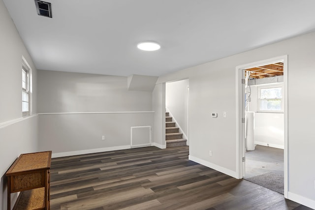 interior space with plenty of natural light, dark wood-style flooring, baseboards, and stairway