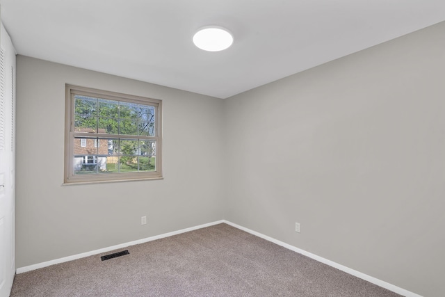 spare room with visible vents, carpet flooring, and baseboards