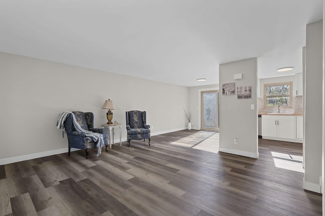 living area with baseboards and dark wood finished floors