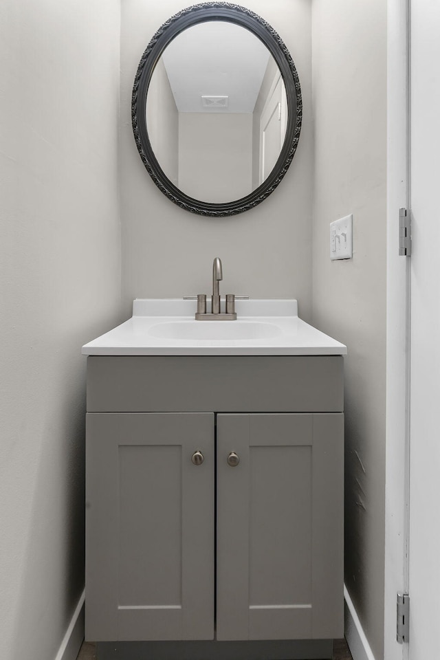 bathroom with baseboards, visible vents, and vanity