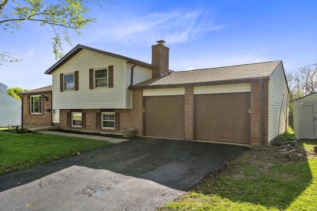 tri-level home with brick siding, driveway, a chimney, and a garage