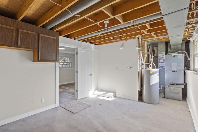 basement featuring baseboards, heating unit, and water heater
