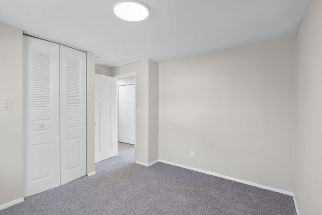 unfurnished bedroom featuring baseboards, carpet, and a closet