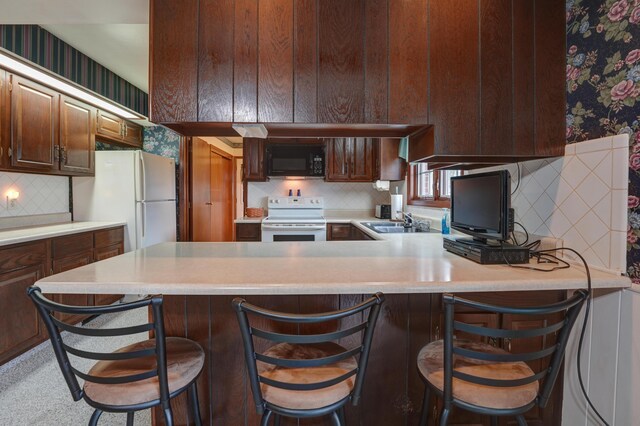 9743 State Route 118, Ansonia, OH 45303 - kitchen with white appliances, a sink, wallpapered walls, decorative backsplash, and light countertops