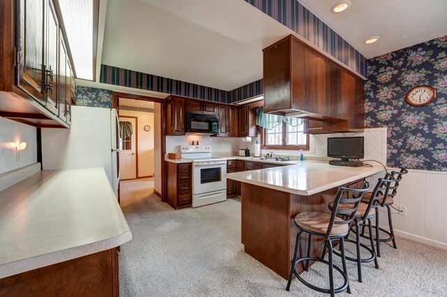 9743 State Route 118, Ansonia, OH 45303 - kitchen featuring white appliances, wallpapered walls, a peninsula, light countertops, and a wainscoted wall