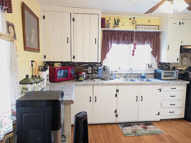 kitchen with a sink, a toaster, light countertops, and electric stove