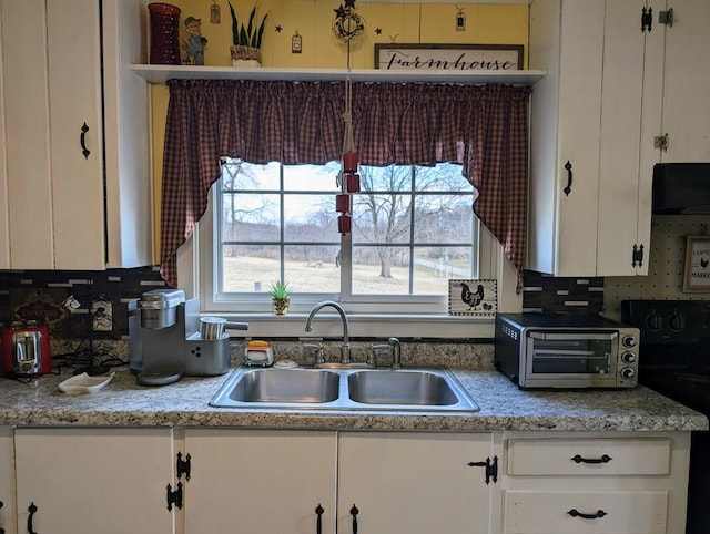 kitchen with a toaster, black range with electric stovetop, range hood, open shelves, and a sink