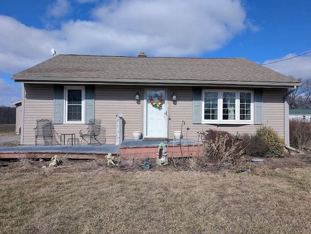 view of front facade with a front lawn and roof with shingles