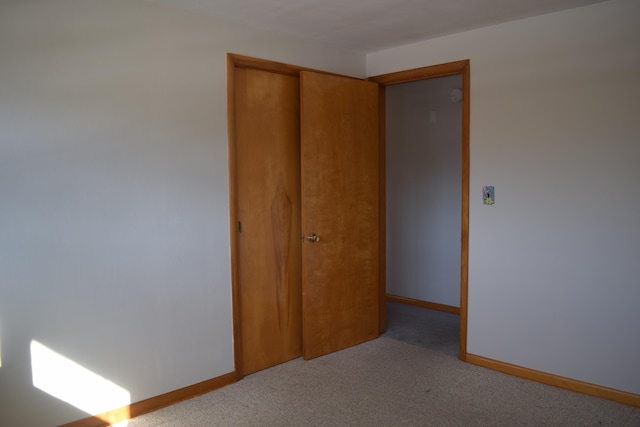 unfurnished bedroom with a closet and light carpet