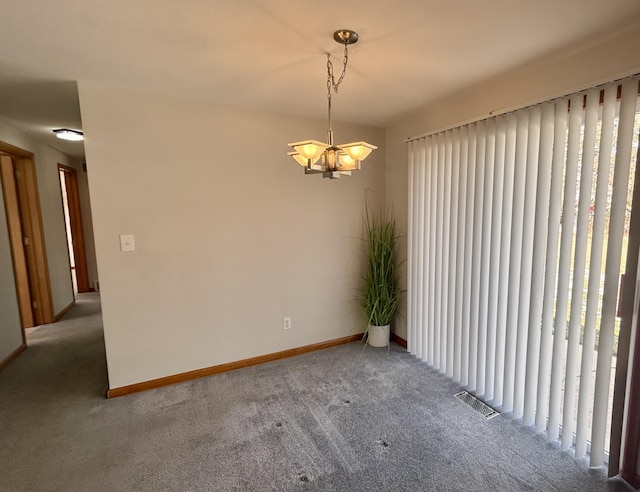 carpeted empty room with a chandelier