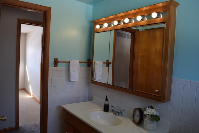 bathroom with vanity and tile walls