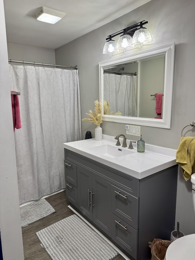 bathroom featuring vanity, a shower with shower curtain, wood finished floors, and visible vents