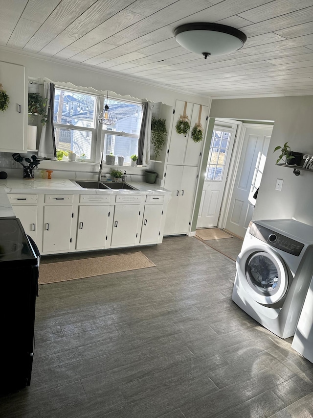 clothes washing area with laundry area, washer / clothes dryer, plenty of natural light, and a sink