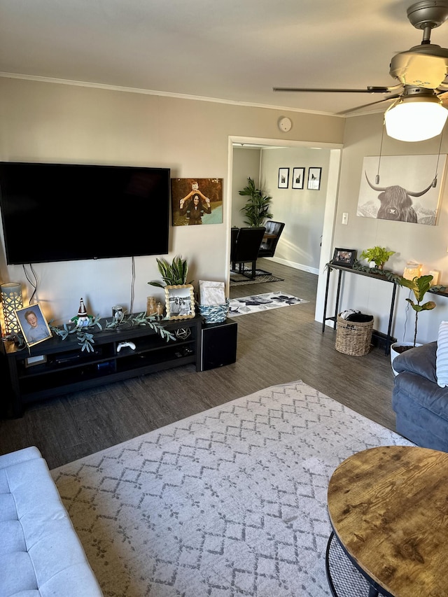 living room featuring wood finished floors, a ceiling fan, and crown molding