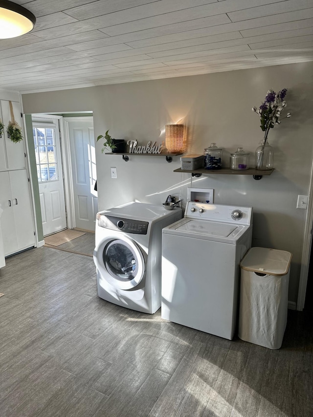 clothes washing area with laundry area, wood finished floors, and washing machine and clothes dryer