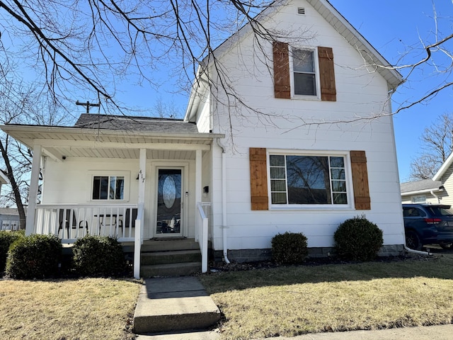 view of front of home featuring a shingled roof, covered porch, and a front lawn