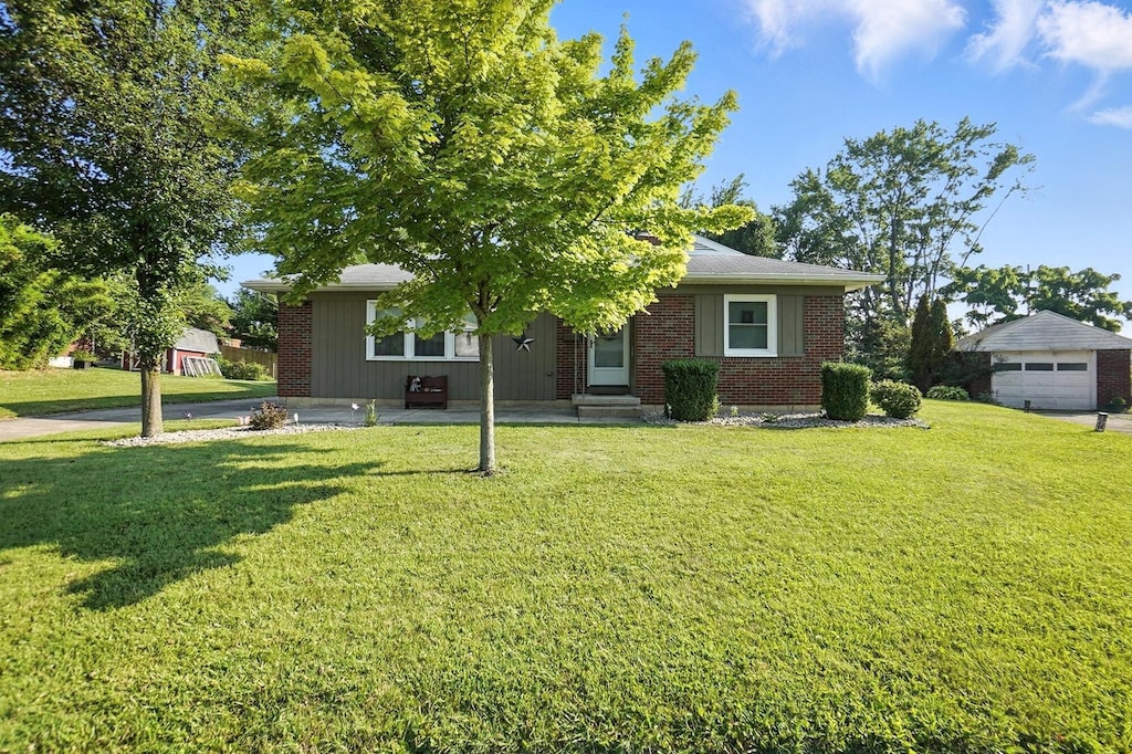 1032 Talisman Cir, Springfield, OH 45503 - view of front facade with a front lawn, brick siding, and a garage