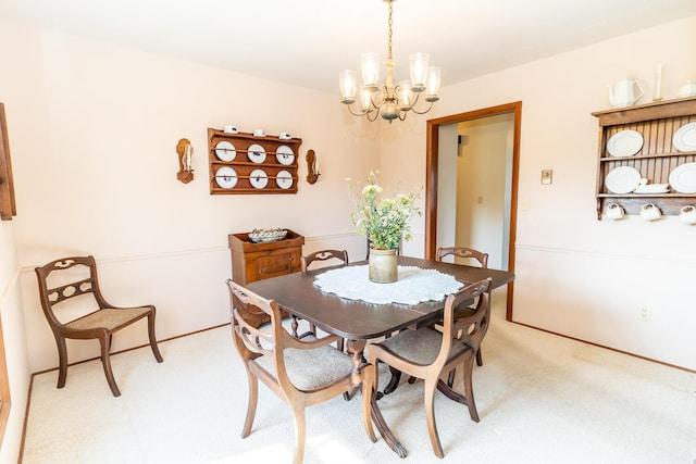 dining area featuring light colored carpet and a chandelier