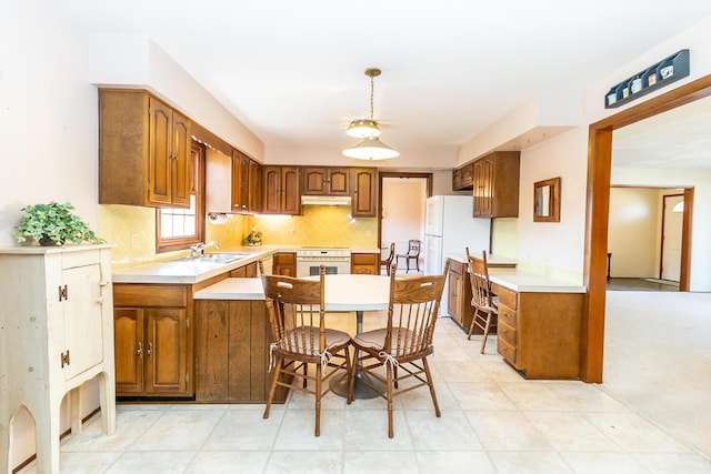 kitchen featuring a peninsula, range, and brown cabinets