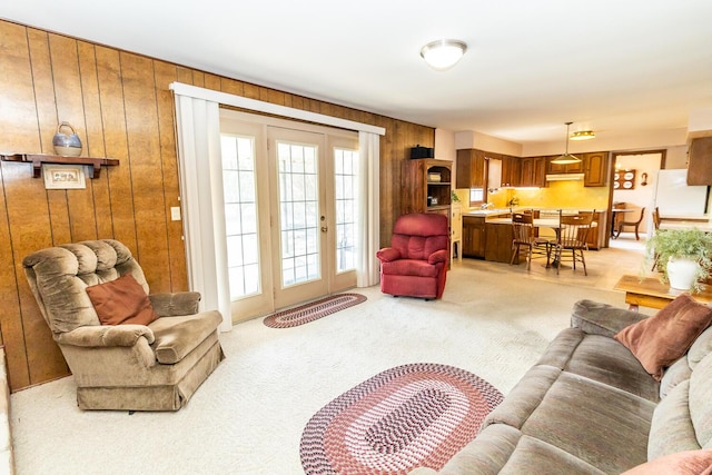 living area featuring light colored carpet and wood walls