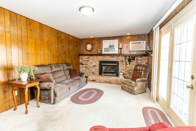 living room featuring a fireplace, carpet, wood walls, and a wall mounted air conditioner