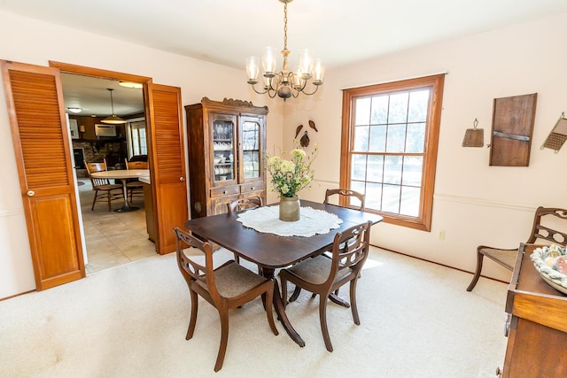 dining room with an inviting chandelier and light colored carpet