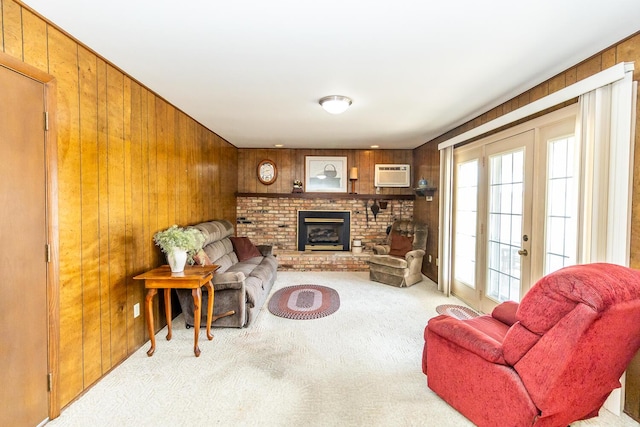 living area featuring wood walls, a brick fireplace, an AC wall unit, and carpet floors