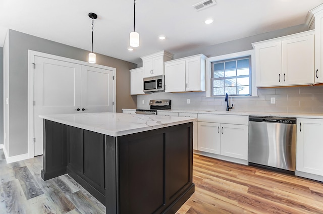 1129 Auburn St, Troy, OH 45373 - kitchen featuring tasteful backsplash, a sink, visible vents, light wood-style flooring, and appliances with stainless steel finishes