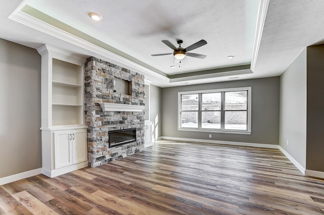 1129 Auburn St, Troy, OH 45373 - unfurnished living room featuring a textured ceiling, a tray ceiling, wood finished floors, and ceiling fan