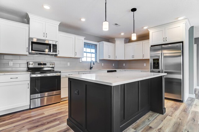 1129 Auburn St, Troy, OH 45373 - kitchen featuring white cabinetry, light wood-style flooring, stainless steel appliances, and backsplash