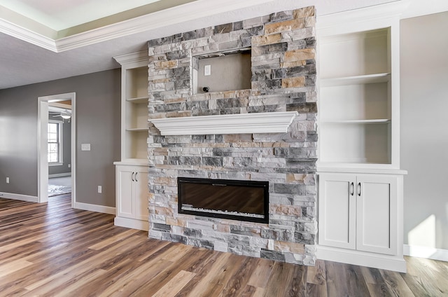 1129 Auburn St, Troy, OH 45373 - interior details with baseboards, built in shelves, a ceiling fan, a stone fireplace, and wood finished floors