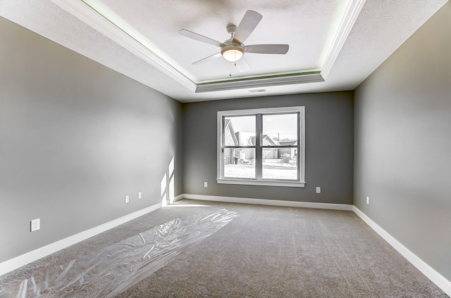1129 Auburn St, Troy, OH 45373 - carpeted empty room with baseboards, a textured ceiling, a tray ceiling, and a ceiling fan
