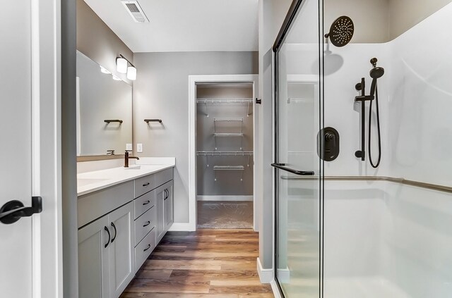 1129 Auburn St, Troy, OH 45373 - bathroom featuring a stall shower, wood finished floors, a spacious closet, visible vents, and double vanity