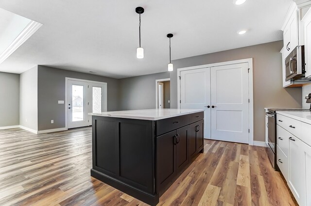 1129 Auburn St, Troy, OH 45373 - kitchen with white cabinets, stainless steel appliances, light countertops, and a kitchen island