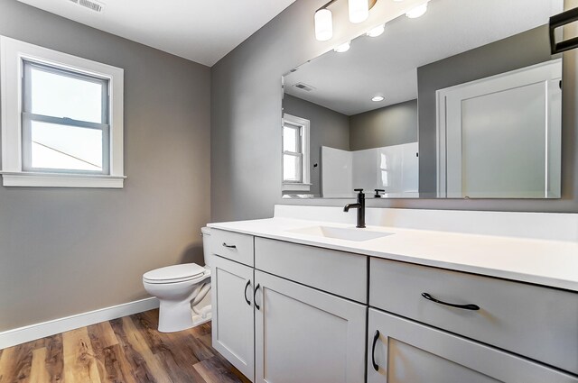 1129 Auburn St, Troy, OH 45373 - full bathroom featuring toilet, vanity, wood finished floors, baseboards, and visible vents